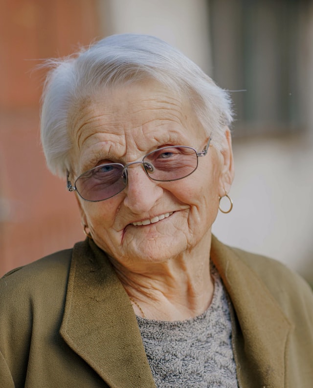 Elderly woman in glasses smiling | Photo by Paréj Richárd on Unsplash